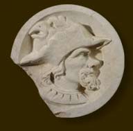 Fragment d'écoinçon sculpté d'un profil d'homme coiffé d'un chapeau au bord découpé, dans un médaillon, provenant du château de Bonnivet