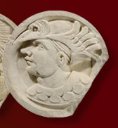 Fragment d'écoinçon sculpté d'un profil d'homme coiffé d'un chapeau à plumes, dans un médaillon, provenant du château de Bonnivet