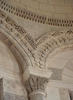 Vue de détail du chœur : chapiteau et motifs décoratifs des arcs et du cordon