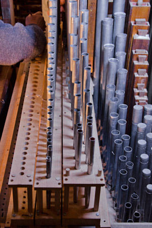 Démontage de l'orgue d'Airvault. Un à un, les tuyaux sont retirés de leur registre.